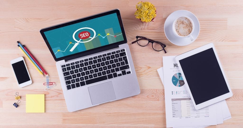 A computer on a desk has a web page about SEO on screen.