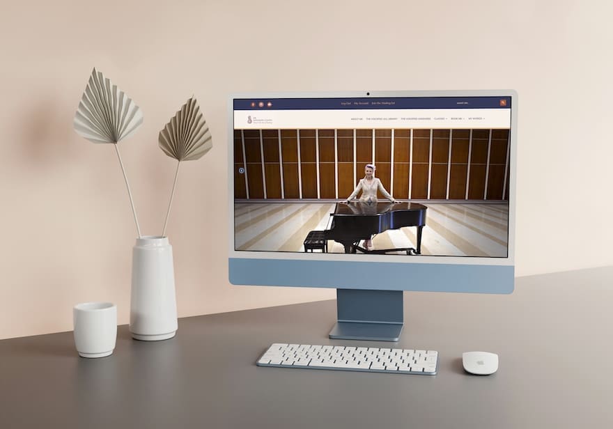 A blue mac computer with a beautiful website design on the display.