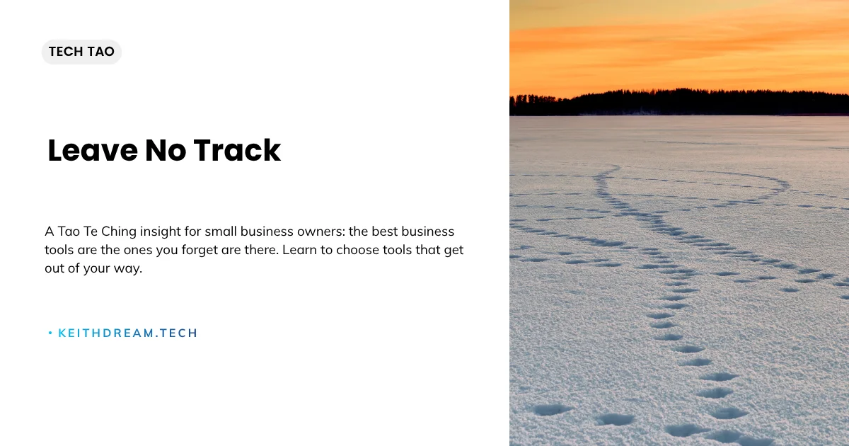 Footprints trailing across a snow-covered frozen lake toward an orange sunset with a dark treeline on the horizon.